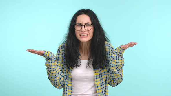 Frustrated Young Woman in Glasses Complaining Shouting What and Spread Hands Sideways Confused