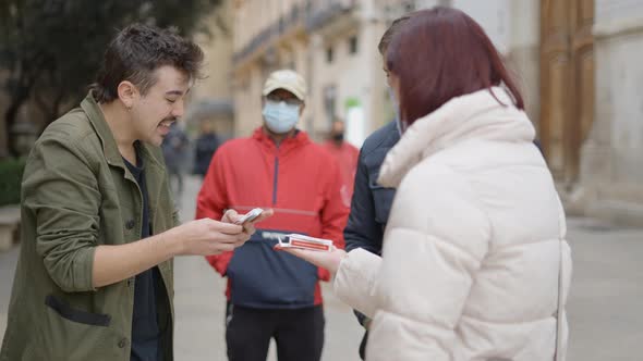 Close Up View of a Male Magician Showing Street Magic Trick with Cards to the Locals Passing By on a