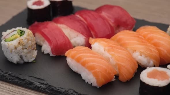 Sushi nigiri salmon, nigiri tuna, hosomaki and uramaki rotating on a plate