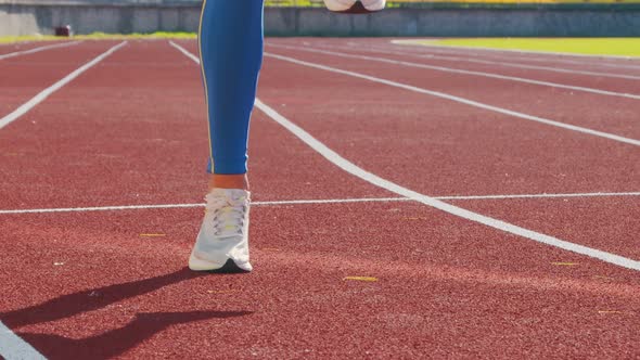 Legs of an Athlete Athlete Who Warms Up Before the Start Bouncing on the Treadmill.