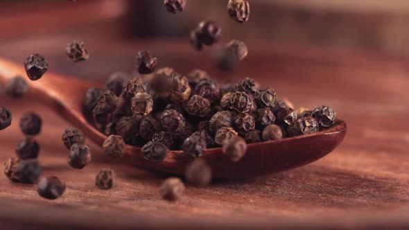 Black Pepper Falling on a Wooden Spoon