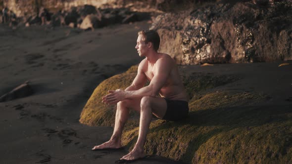 Portrait of Young Athletic Man Resting After Training on the Rock