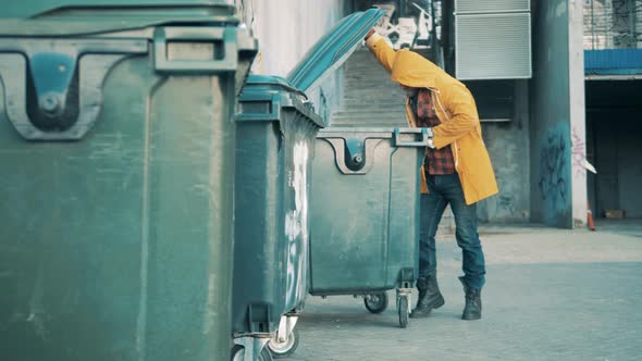 A Tramp is Rummaging in the Trash Bins