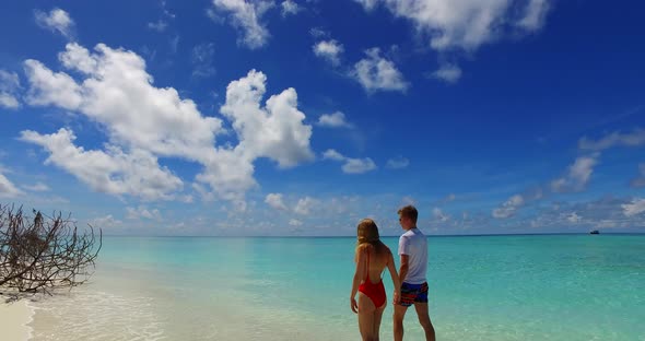 Romantic boy and girl in love dating on vacation have fun on beach on clean white sand background 