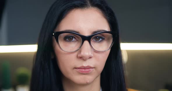 Woman in Glasses Looking at Camera on the Home Background