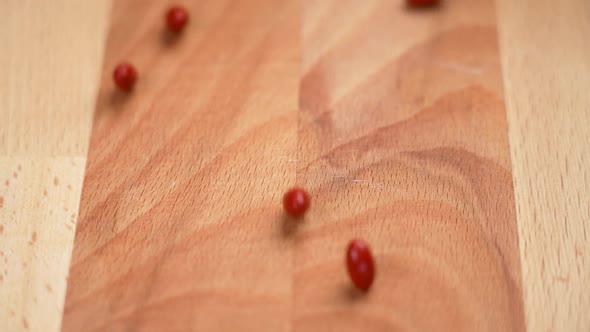 Brown vitamin A pills rolling on a wooden surface in slow motion