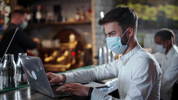 Young Man Freelancer Works Outside the Home a Young Businessman Developer in a Medical Mask Sits at