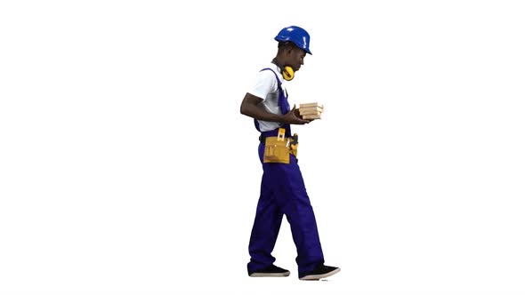 African American Builder Goes To Work with Wooden Planks in His Hands. Alpha Channel. Side View