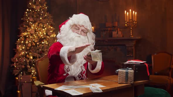 Workplace of Santa Claus. Cheerful Santa is working while sitting at the table.
