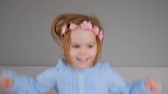 Cute happy little girl jumping on bed