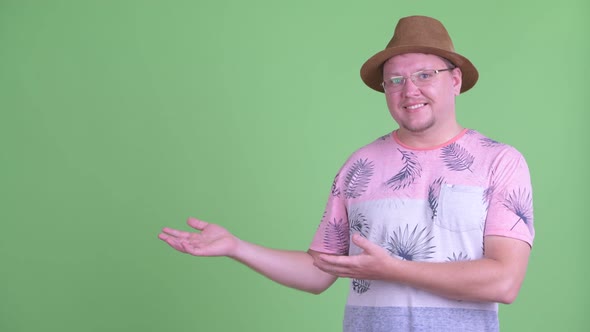 Happy Overweight Bearded Tourist Man Showing Something