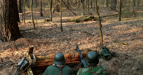 German Wehrmacht Infantry Soldier In World War II Prepare for Shooting Machine Gun From Forest