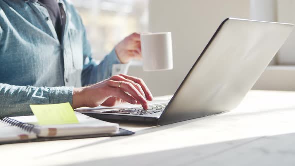 Young male entrepreneur works at home office at the computer.