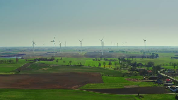 Farm of wind turbines on spring field in sunny day, Poland