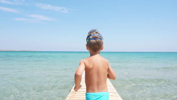 Happy Little Boy Runs Into the Sea, Enjoying Summer Holidays. Clear Blue Water, Golden Sandy Beach.