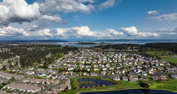 Wide aerial shot pulling away from Oak Harbor's vast sea of suburban homes on Whidbey Island.