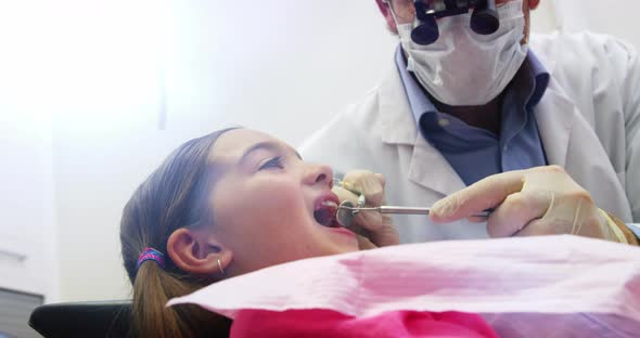 Dentist examining a young patient with dental tools