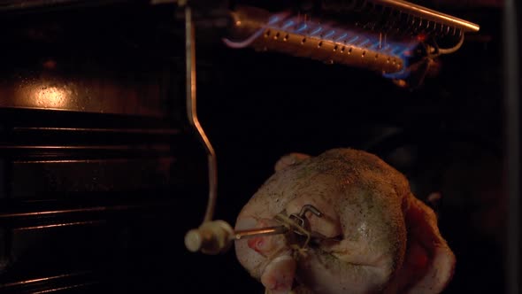 The Chicken in the Oven Roasting on a Spit.