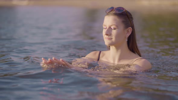 Attractive girl swimming at a sunny beach