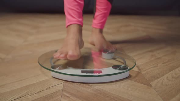 Barefoot Female Legs Standing on Weighing Scale