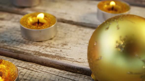 Burning candles on wooden plank