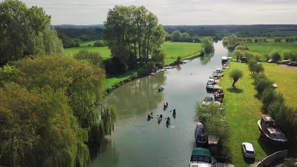 People Paddling Kayak On River Thames In Abingdon Town, Oxford City, UK During Summertime. - aerial 