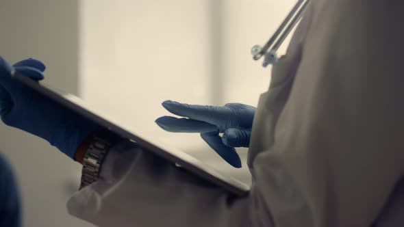 Physician Hands Holding Pad Computer Checking Patient Data in Hospital Close Up