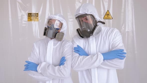 Two Doctors in Medical Protective Suits in a Hospital with Their Arms Crossed