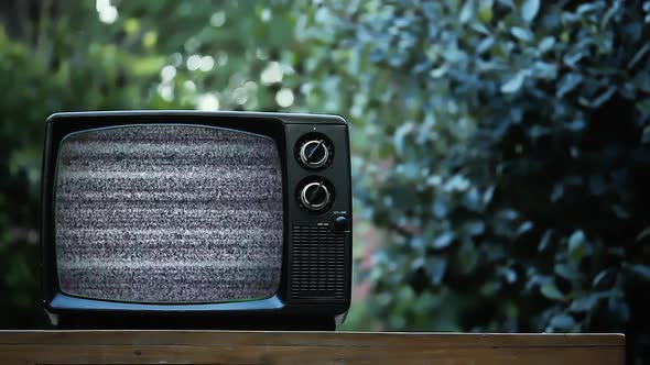 Old Retro TV Set turning on Green Screen with Static and Color Bars Outdoors. 