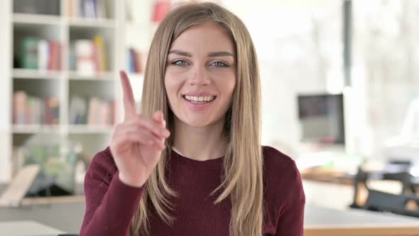 Portrait of Beautiful Young Woman Pointing with Finger