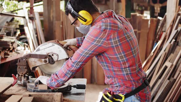 Carpenter working on woodworking machines in carpentry shop