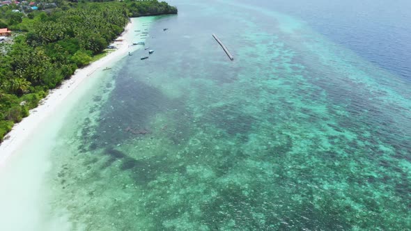 Aerial: Flying over tropical beach turquoise water coral reef , Indonesia