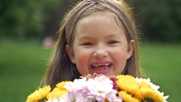 Summer Portrait of a Cheerful Girl 67 Years Old with a Bouquet of Flowers