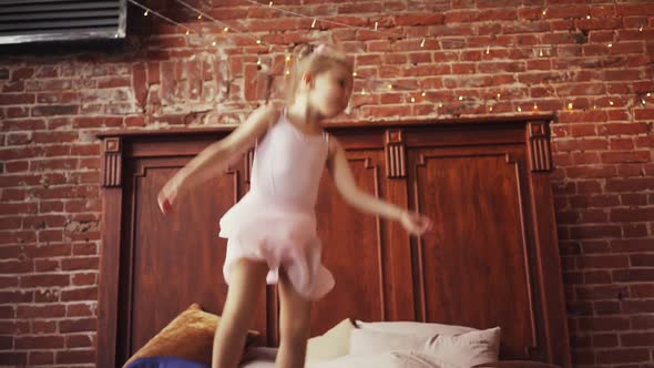 Cute Baby Girl Blonde Jumping on the Bed