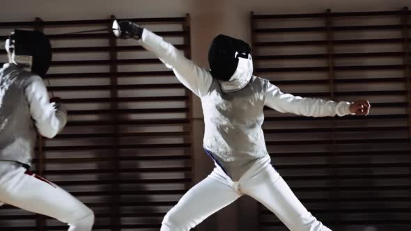 Men in Fencing Masks Thrusting with Foils in Duel