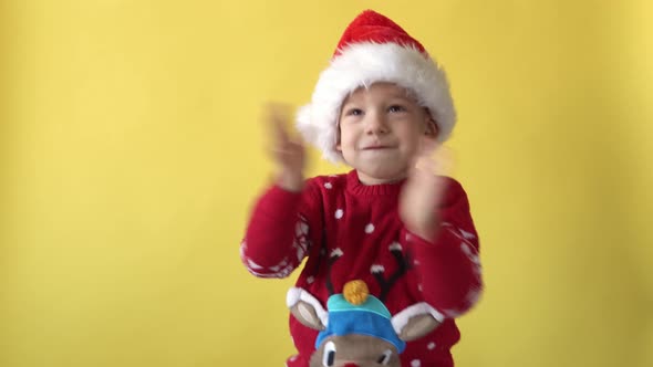 Portrait Emotion Cute Happy Cheerful Chubby Preschool Baby Boy in Santa Hat Looking On Camera At