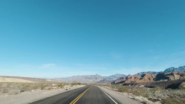 Car Driving on Sunny Day in Death Valley National Park. California, USA