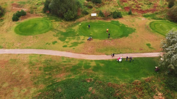 Drone Outdoor Shot of a Group of People Standing Near a Dirt Road on a Golf Course Having Fun