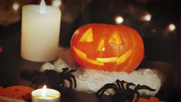 Lighting carved pumpkin with spooky face, skeleton and burning candles. Halloween greetings