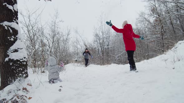 Happy Family Playing Sowballs with Dog Jack Russell Terrier In Snowy Day In Forest
