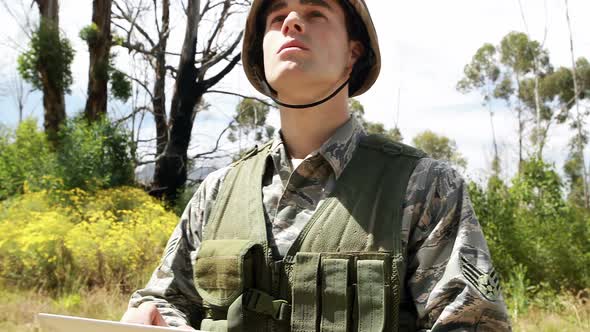 Military soldier using digital tablet during training exercise