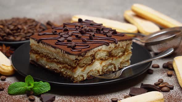 Portion of Traditional Italian Tiramisu dessert, coffee beans and savoiardi cookies