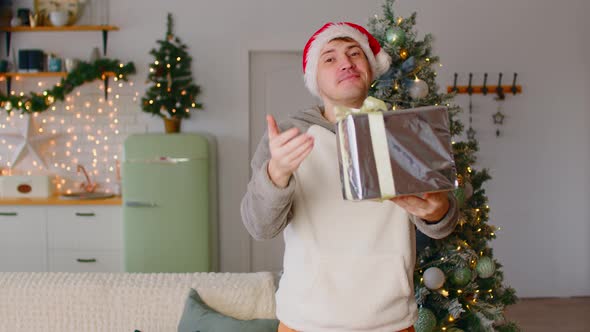 Man Giving Christmas Gift to Camera