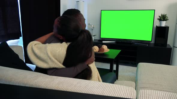 Young Black Happy Couple Watch Television in Living Room and They Rejoice