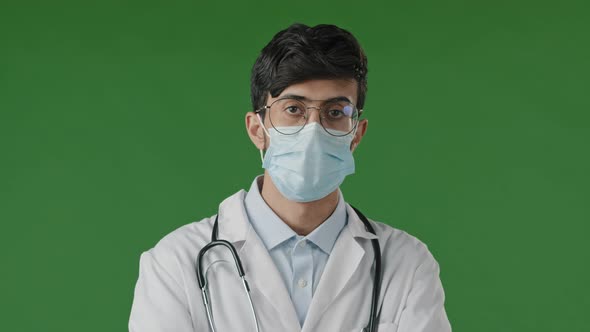 Portrait of Young Guy Doctor in Studio on Green Background Serious Hispanic Man in Protective