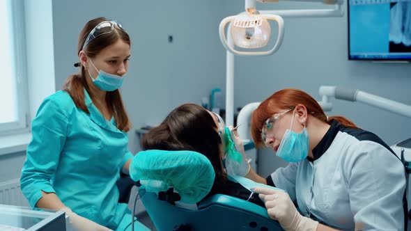 Girl patient and dentist. Dentist treating teeth to woman patient in clinic