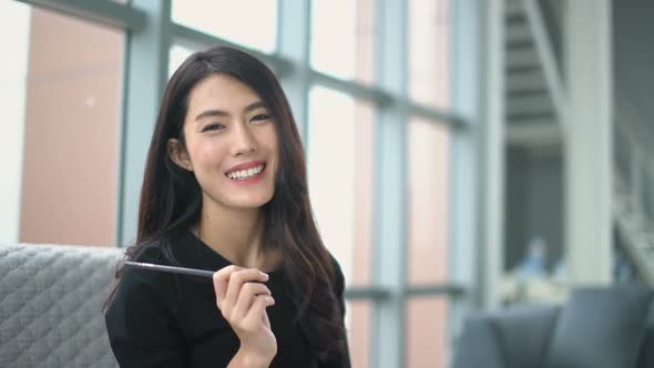 attractive asian woman black dress working and note on paper sit on sofa