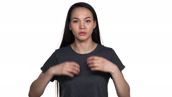 Portrait of Brunette Annoyed Asian Woman 20s in Casual Tshirt Gesturing in Furious Manner and Asking