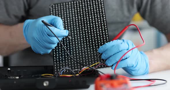 Electrician Uses Tester to Check Contacts in Board