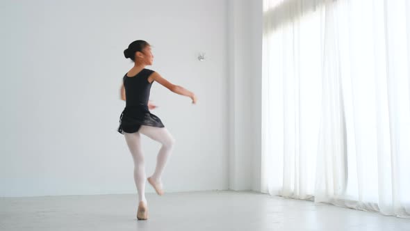 Asian ballet little girl stand and practice the dancing with raising the legs in room